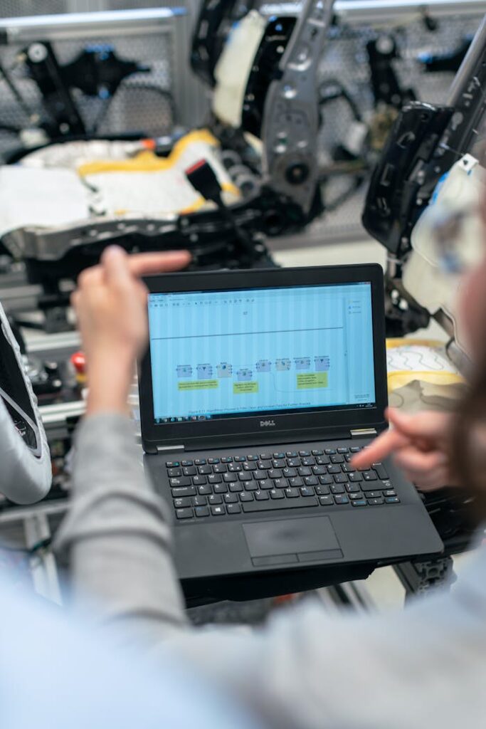 pexels-photo-3862605 Engineers using a laptop to analyze software data in an industrial workshop setting.